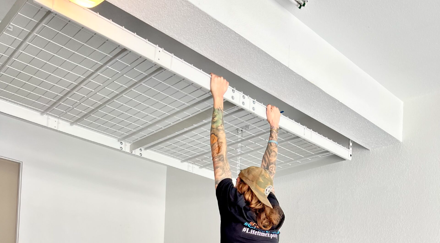 Installer testing the strength of a ceiling storage rack